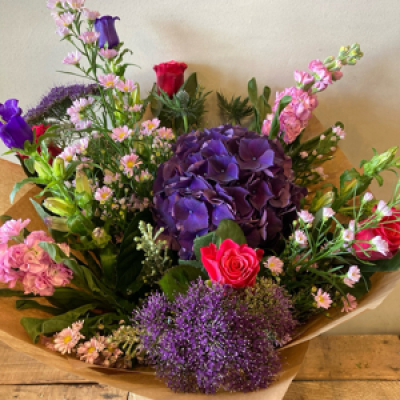 Summer Vibes - Florist has choose a selection of summer flowers in pinks,lilic and purple to create a summer garden selection. Perfect for any occasion with minimal plastic used. Created as a handtie delivered in a bubble of water.